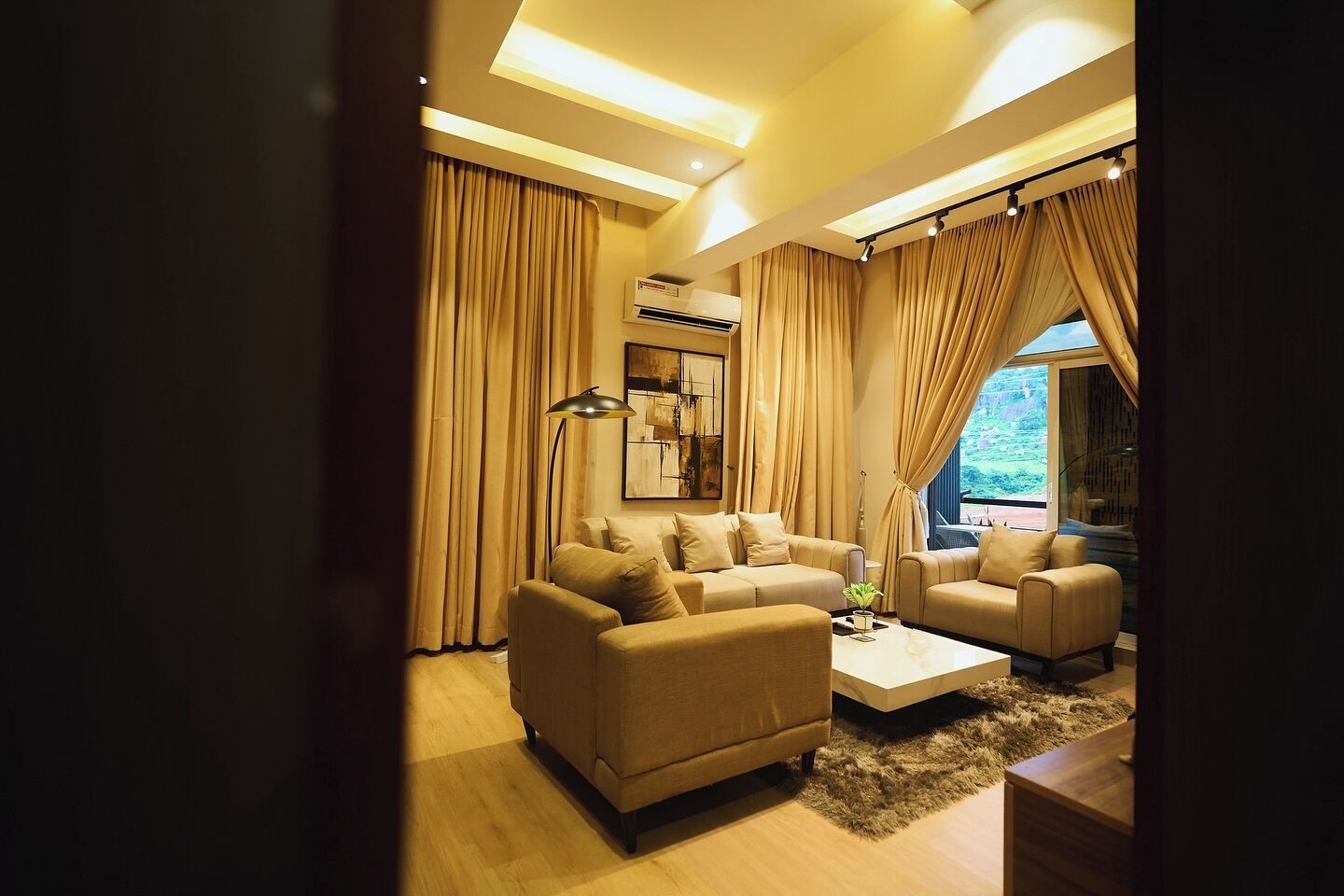 A modern living room with two sofas, a coffee table, and a large window with curtains.