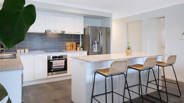 A modern kitchen with white cabinets, stainless steel appliances, and a central island with bar stools. - Dakabin Escape Modern Comfort near Dining and Shops (Dakabin)