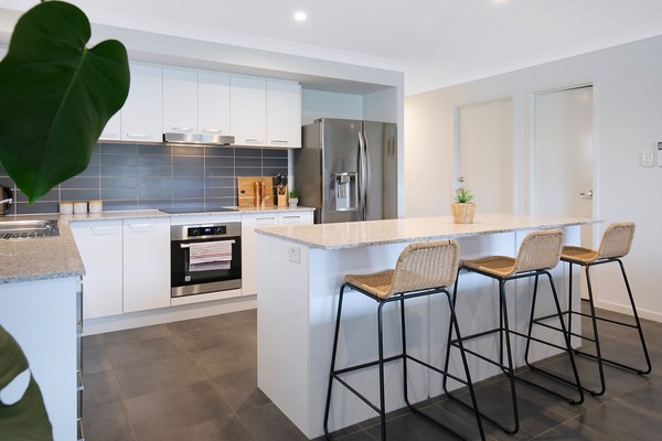The kitchen island with woven stools creates an inviting spot for morning coffee, casual meals, or shared cooking.