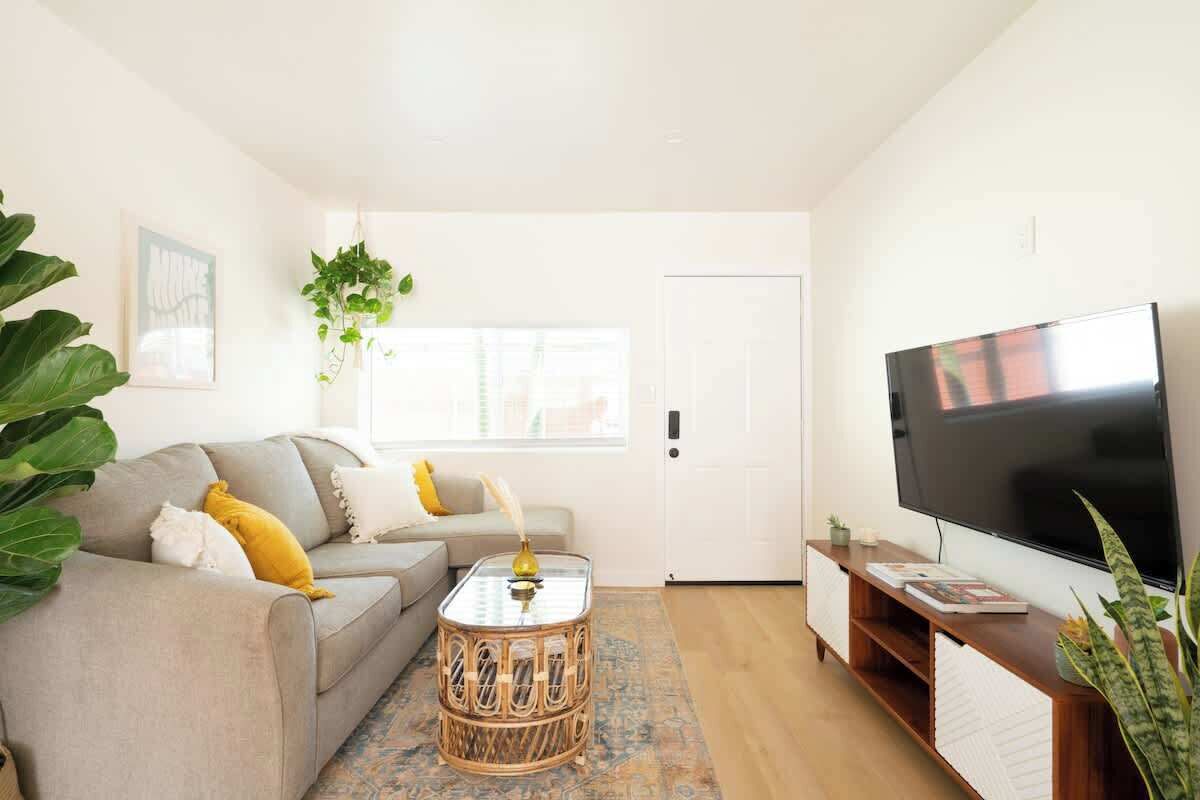 A living room with a sofa, a coffee table, a TV, and a door.