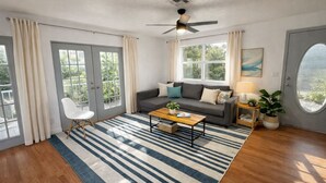 A modern living room with a sofa, coffee table, and a view of greenery through large windows.