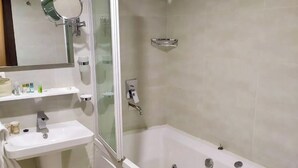 Un baño moderno con bañera, lavabo, espejo y ducha.