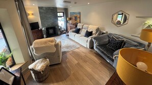 A living room with a fireplace, a sofa, a chair, a lamp, and a mirror. - Havendale (Chesterfield)