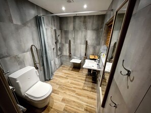 Et moderne badeværelse med toilet, bruser og håndvask.