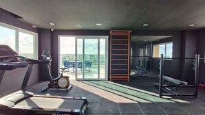 A gym with exercise equipment, a treadmill, an elliptical, a bench, and a rack of weights. - COPDS0110 - Pedra do Sal Privilege (Salvador)