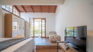 Une chambre à coucher avec un lit, une télévision, une chaise et une armoire.