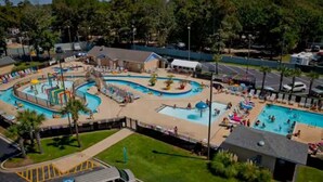 Et stort udendørs poolområde med flere pools og en vandrutsjebane.