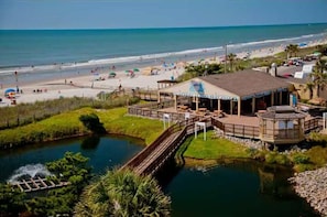 Ein Hotel am Strand mit Pool, Terrasse und Blick auf Strand und Meer.