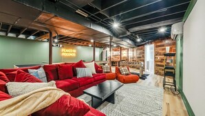 Un soggiorno moderno con un divano rosso, un tavolino da caffè nero e un neon con la scritta "PEAKED IN POCONOS".