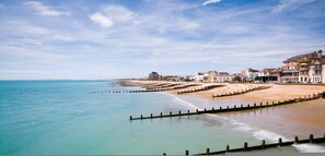 A coastal town with a sandy beach, a promenade, and buildings along the shore. - Coastal Comfort for 6 Felpham Beach (Bognor Regis)