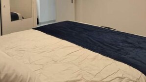 Une chambre à coucher avec un lit, une porte et un luminaire.