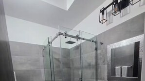 A modern bathroom with a glass-enclosed shower, a white sink, and a large mirror. - Cerca de Casa de Dios, Decocity Pradera Concepcion (Fraijanes)