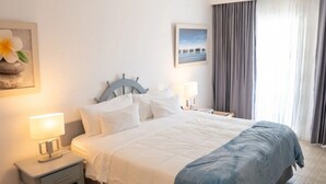Ett hotellrum med en säng, sängbord, en takfläkt och ett fönster med gardiner.