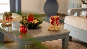 Ett matbord dekorerat för jul, med bland annat ett ljus, ett litet julgran och en korg med ett band.