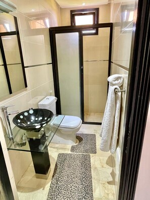 A modern bathroom with a glass sink, a white toilet, and a shower area. - Luxury villa with a heated pool (Marrakech)