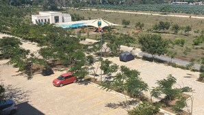 Un espace de stationnement avec quelques voitures, une aire de jeux et un bâtiment en arrière-plan.