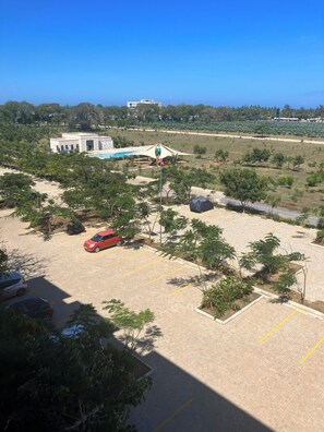 Een parkeerplaats met enkele auto's, een speeltuin en een gebouw op de achtergrond.