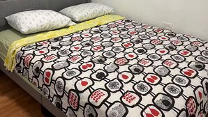 A bed with a patterned bedspread, two pillows, and a yellow blanket. - 2 bedrooms in Hato Rey (San Juan)