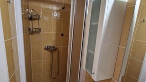 Ein Badezimmer mit Dusche, Toilette und Waschbecken.