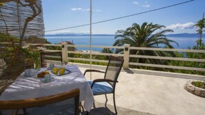 Ein Tisch im Freien mit Blick auf Meer und Berge.