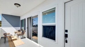 A modern exterior with a covered patio, large windows, and a white garage door.