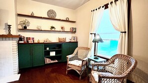 A cozy room with a fireplace, green cabinets, wicker chairs, and a view of the ocean. - 2 Bdrm home close to downtown Ames, Jack Trice, Hilton Coliseum & Stephens (Ames)