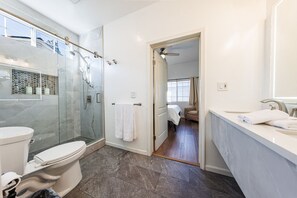 A modern bathroom with a glass-enclosed shower, a toilet, and a sink area. - Welcoming and Spacious 2-Bedroom Suite in Central Torrance, California (Torrance)