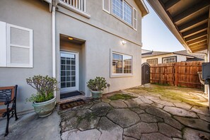 A house with a stone patio, a wooden fence, and two potted plants. - Welcoming and Spacious 2-Bedroom Suite in Central Torrance, California (Torrance)