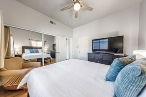 A hotel room with a large bed, a television, a wardrobe, and a sliding door leading to another room. - Welcoming and Spacious 2-Bedroom Suite in Central Torrance, California (Torrance)