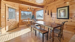Ein Holzkamin mit einem Esstisch, Bänken und Stühlen.