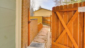 A narrow pathway leading to a wooden gate with a sign. - 6 Mi to Dtwn Fort Collins: Cozy Apt w/ Shared Yard (Fort Collins)