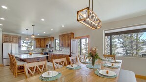 Une cuisine moderne avec des meubles en bois, un îlot central et des luminaires suspendus.