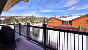 En balkong med utsikt över snötäckta byggnader och en klar himmel.