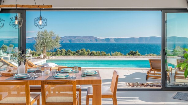 A dining area with a view of the sea, a pool, and outdoor seating. - Amazing home in Ravni with sauna (Ravni)