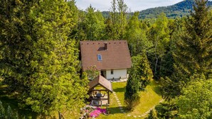 Une maison entourée d’une forêt dense, offrant une vue dégagée sur le ciel.