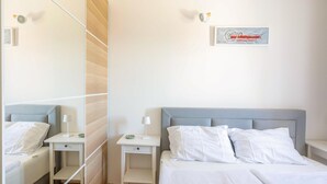 A hotel room with a bed, a bedside table, a nightstand, a mirror, and a wall-mounted artwork. - 1 bedroom amazing apartment in Veli Losinj (Veli Losinj)