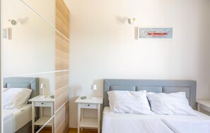 A hotel room with a bed, a bedside table, a nightstand, a mirror, and a wall-mounted artwork. - 1 bedroom amazing apartment in Veli Losinj (Veli Losinj)