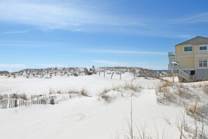 A beach house with a sandy beach and dunes in the background. - Beachfront Bliss with Panoramic Gulf Views | Sandpiper Cove 2152 Destin, FL (Destin)