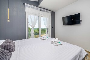 Une chambre d’hôtel avec un lit, une télévision et une vue sur l’extérieur.