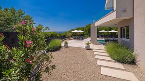 A modern house with a patio, outdoor seating, and a swimming pool. - Villa LA VIE with private pool (Garica)