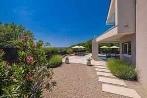 A modern house with a patio, outdoor seating, and a pool. - Villa LA VIE with private pool (Garica)