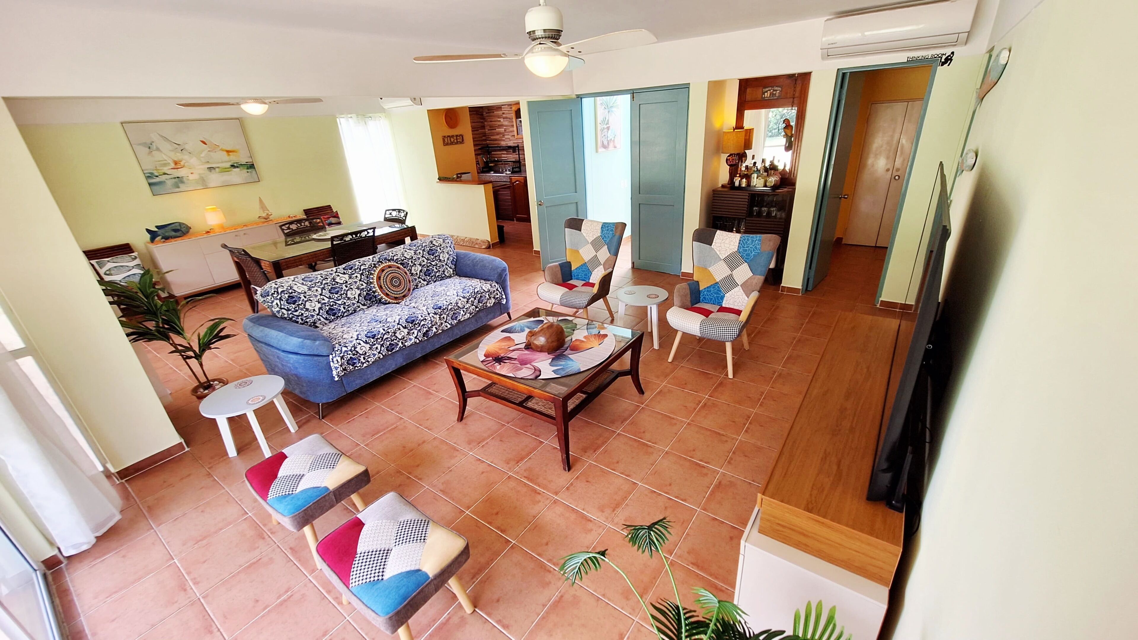 A spacious living area with a sofa, chairs, a coffee table, and a dining table.
