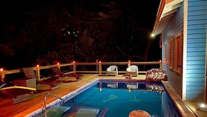 A swimming pool with lounge chairs and a deck area. - Beautiful West Bay Beach large 4 br with pool. (West Bay)