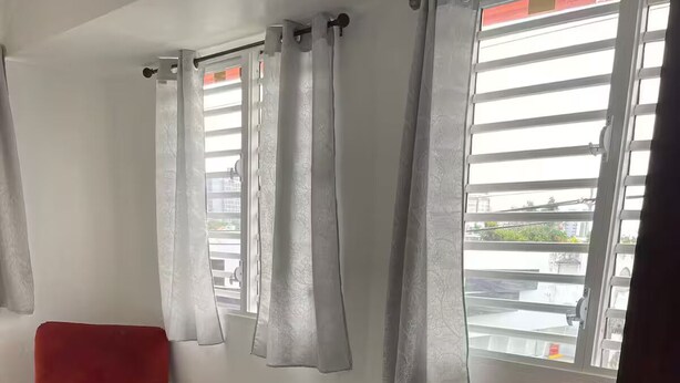 A room with two red chairs, a small table, and a window with grey curtains. - New in market, Hato Rey 2 bedrooms -301- (San Juan)
