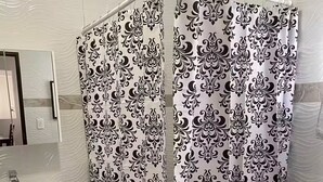 A bathroom with a shower curtain featuring a black and white damask pattern, a white sink, and a toilet. - New in market, Hato Rey 2 bedrooms -301- (San Juan)