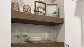 A kitchen with white cabinets, wooden shelves, and a stainless steel faucet. - Brand New! Downtown Stratford: The Blowes Inn 3C: 2 Bedrooms (Stratford)