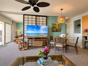 A living room with a television, wicker furniture, a ceiling fan, and a view of the ocean. - 2 Kings | Top Floor Oceanfront | Big Lanai | Views from the Top (Lahaina)