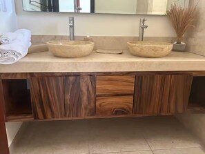 A bathroom with two beige ceramic sinks, a wooden vanity, and a mirror above the sink. - Beautiful Ocean view 2 BD Condo (Bajos de Chila)