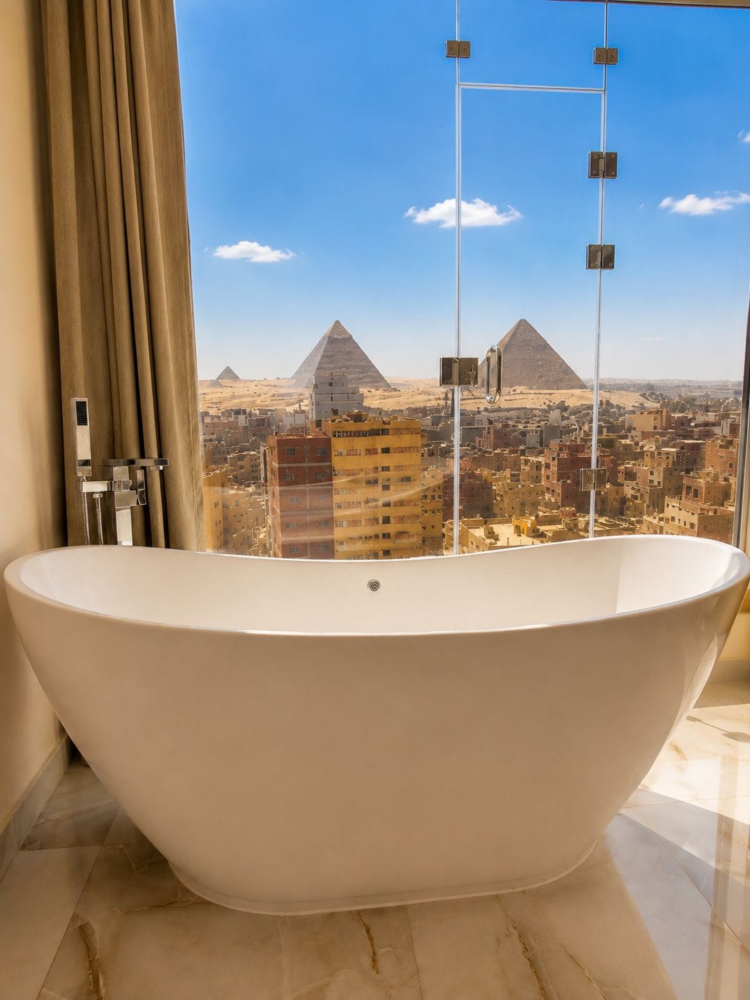 A bathroom with a freestanding bathtub, a window with curtains, and a view of the pyramids.