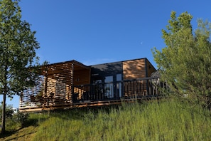 A modern building with a wooden exterior, a balcony, and a staircase. - Modernes Mobilehome im Vital Camp Bayerbach (Bayerbach)